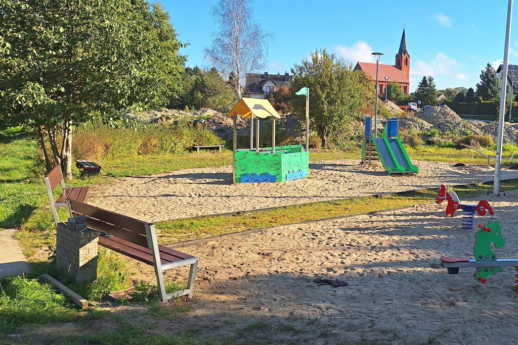 Widok ogólny placu zabaw — ławki i urządzenia